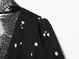 Close-up of elegant black floral dress fabric with delicate eyelash lace trim detail