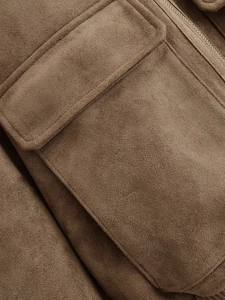 Detail of dark brown suede jacket featuring a large flap pocket and metal zipper closure