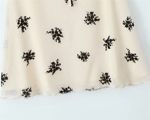 Close-up of floral print chiffon dress with delicate wavy hem and sheer fabric texture