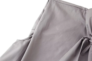 Dettaglio della camicia a righe grigio-viola con cuciture precise e fiocco decorativo
