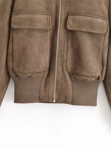 Detail of suede jacket with metal zipper closure, utility flap pockets, and ribbed hem