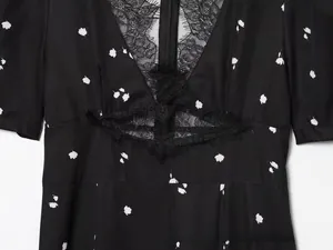Detail of V-neckline with delicate black eyelash lace and floral chiffon fabric