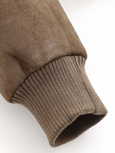 Close-up of brown suede jacket cuff with textured ribbed knit detail and soft material