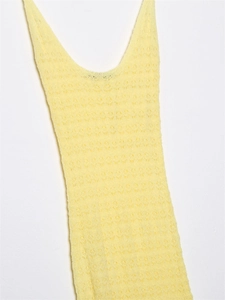 Detail view of yellow crochet knit fabric with intricate hollowed mesh patterns