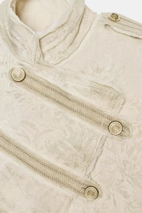 Detail of cream jacquard jacket with gold embossed buttons and military shoulder tabs
