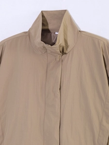 Close-up of khaki windproof high collar jacket with zipper cover and size S label detail