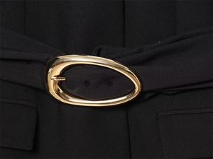 Détail du blazer noir avec texture tissée et boucle de ceinture ovale en métal doré