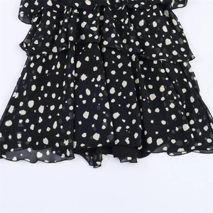 Chic black tiered ruffle dress with white polka dot patterns and lightweight chiffon fabric