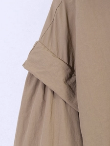 Close-up of khaki woven fabric showing premium seam details and smooth texture on jacket