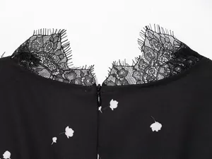 Detailed close-up of the elegant eyelash lace trim and invisible zipper on the black dress