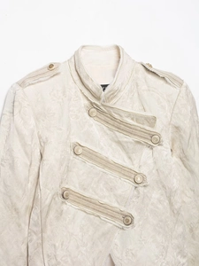 Detail of ivory military jacket with jacquard floral patterns and vintage metal buttons