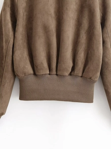 Close-up of brown suede jacket with ribbed hem and high-quality matte fabric texture