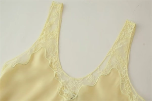 Gros plan du haut en satin jaune pâle avec dentelle délicate et texture soyeuse