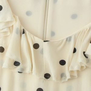 Robe à pois blanc cassé chic avec des volants élégants et une fermeture éclair cachée