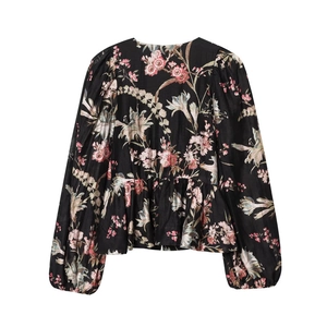 Detail of floral printed blouse with gathered waist and elegant ruffled hemline