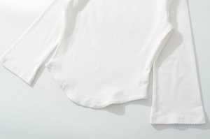 Detailed macro view of the delicate lace trim and scallop edging on white cotton sleeve cuffs