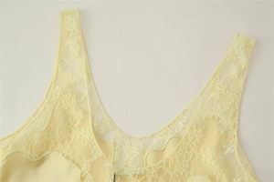 Détail de la dentelle florale et du tissu satiné lisse sur un débardeur jaune pâle