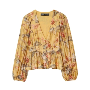 Detail of floral V-neck peplum blouse with mustard yellow fabric and long lantern sleeves