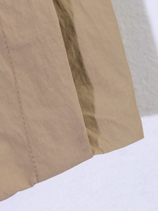Detailed macro view of khaki windproof fabric with precise stitching and hem finish
