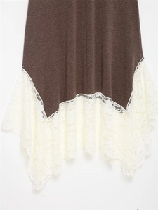 Detail of winter dress featuring deep brown knit fabric and white floral lace hemline