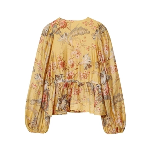 Close-up of vintage yellow floral shirt featuring puff sleeves and tiered ruffle hemline
