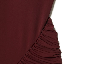 Dettaglio macro dell'elegante trama arricciata bordeaux su un abito estivo