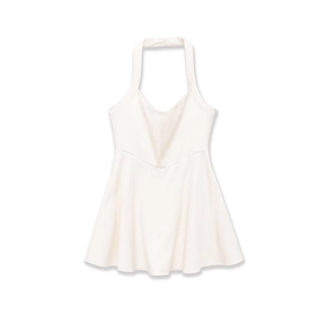 Detail of white halter neck mini dress featuring curved seam under the bust and A-line cut