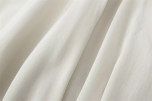 Macro shot of high-quality white cotton fabric texture with natural wrinkle details