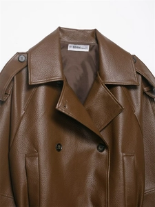 Detail of brown faux leather trench coat showing lapels, shoulder tabs and litchi texture