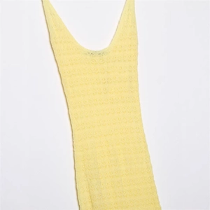 Elegant light yellow knitted sleeveless dress featuring delicate geometric crochet patterns