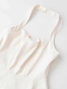 Close-up of cream white halter dress with twill texture and deep V-neckline detail