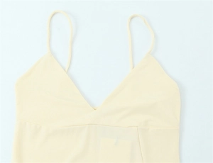 Detailed close-up of pale yellow V-neck camisole top with thin straps and textured fabric