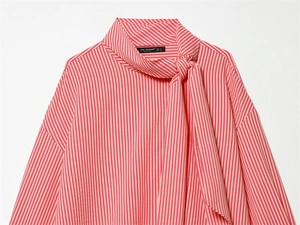 Detail of red stripe shirt featuring pussy-bow neck and branded woven label