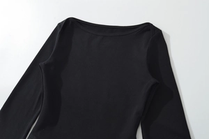 Detail of boat neck collar and premium black knit fabric texture on slim fit top