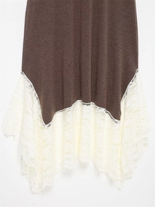 Detail of coffee brown knit dress showing asymmetric lace patchwork hem with floral pattern