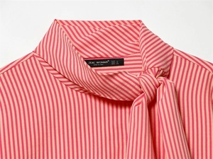 Detail shot of striped shirt neckline with ribbon tie and Zeal Woman brand label
