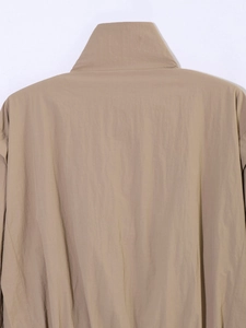 Detail view of khaki jacket back featuring high collar and fine textured windproof fabric