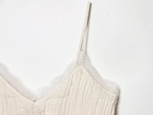 Detail of ivory pleated camisole with delicate eyelash lace trim and thin shoulder straps
