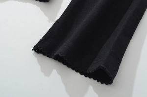 Macro shot of black T-shirt cuff with ruffled lettuce trim and dual-line stitching detail
