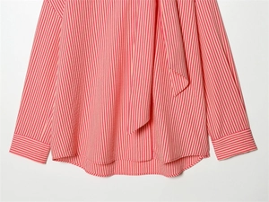 Detail of coral pink striped shirt showing stand collar with elegant bow tie decoration
