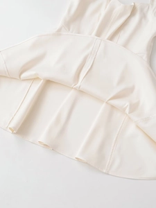 Close-up of ivory dress hem showing premium fabric texture and stitching details