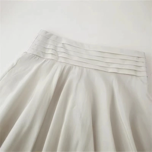 Elegant beige high waist pleated midi skirt with layered ruffles and textured fabric