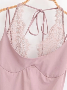 Vue détaillée du body rose avec dentelle délicate et fines bretelles de style licou