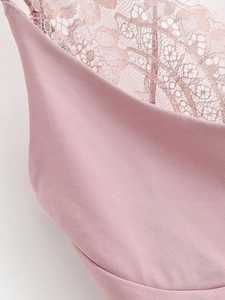Détail du body rose montrant le contraste entre le tissu lisse et la dentelle florale