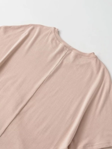Close-up of the back neckline and vertical seam detail on a pink short-sleeve t-shirt