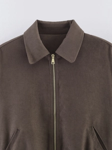 Detail of caramel brown cotton jacket showing golden zipper and polo collar texture