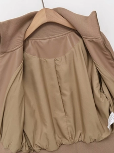 Detail shot of the inner lining and washing label of the tan faux leather bomber jacket