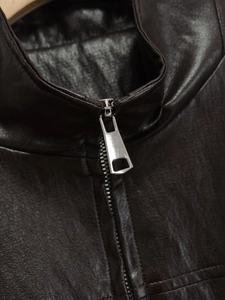 Dettaglio giacca in ecopelle marrone scuro con colletto rialzato e zip in metallo argento
