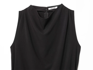 Detail of cowl neck on sleeveless black top with inner brand label and back zipper