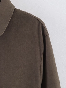 Detail of premium textured fabric and polo collar stitching on brown casual jacket